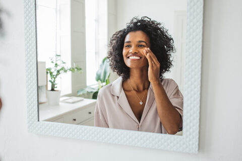 happy woman looking at the mirror