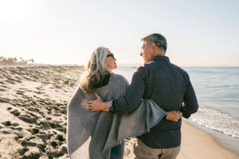 Old couple roaming on a beach